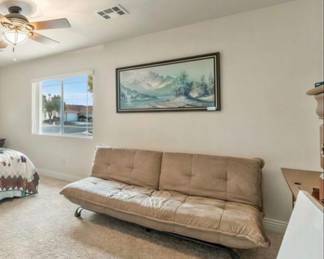 Modern convertible futon sofa with padded tufted cushion and sturdy metal frame.