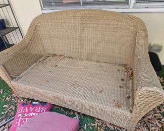 This woven rattan  loveseat has cushions  
