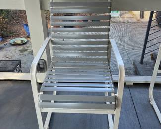 C28 - $350. Woodard Furniture Glass Top Table & 4 Vinyl Strap Chairs. Measures 47.5" round x 28" tall. Chairs are 23.5" x 25.5" x 36" tall. Has been used on a screened in porch - a few very minor rust spots