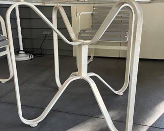 C28 - $350. Woodard Furniture Glass Top Table & 4 Vinyl Strap Chairs. Measures 47.5" round x 28" tall. Chairs are 23.5" x 25.5" x 36" tall. Has been used on a screened in porch - a few very minor rust spots