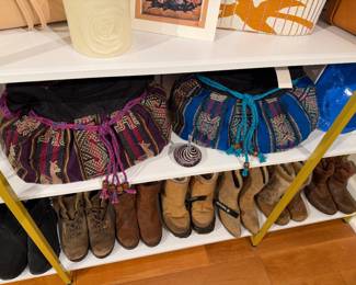 Shelf display featuring woven fabric handbags with drawstring closures above a row of assorted boots.