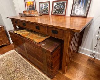 Mission style oak console table with three drawers and slatted side panels.