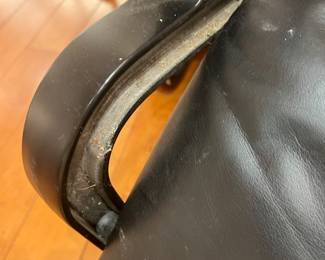 Black Leather Chaise Lounge – Modern black leather reclining chaise lounge chair with curved metal frame and head cushion, minimalist contemporary design.