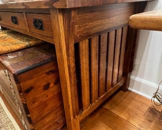 Mission style oak console table with three drawers and slatted side panels.