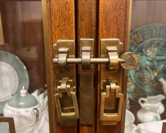 A mid-20th-century (1950s–60s) American china/display cabinet with Asian-influenced geometric brass trim and walnut/pecan veneer.