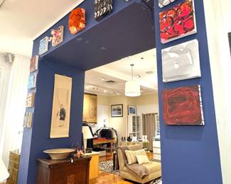 A gallery-style architectural opening decorated with multiple small contemporary abstract paintings, late 20th–early 21st century contemporary art display.