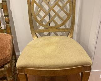 Gold-finish accent dining chair with geometric circular back design and upholstered seat.