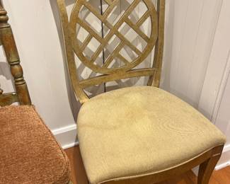 Gold-finish accent dining chair with geometric circular back design and upholstered seat.