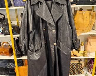 Black double-breasted long coat with oversized lapels and textured finish.