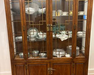 A mid-20th-century (1950s–60s) American china/display cabinet with Asian-influenced geometric brass trim and walnut/pecan veneer.