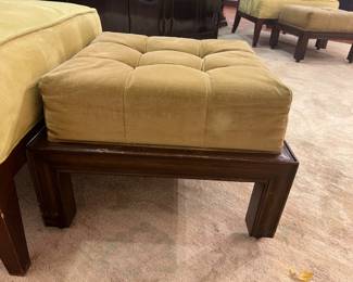 Vintage tufted upholstered ottoman bench with wood frame and brass casters.