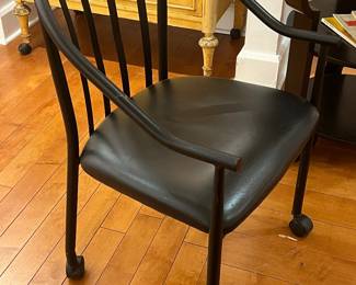 Rolling Armchair – Contemporary black armchair with cushioned seat, curved backrest, and rolling casters for easy mobility.