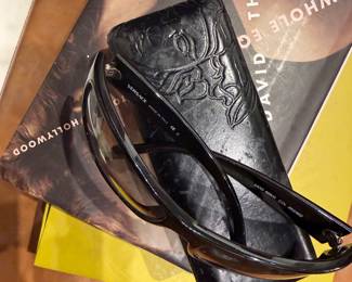 Versace black designer sunglasses with logo arms and protective case.