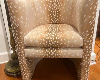 Contemporary upholstered barrel chair in beige and white spotted fabric.