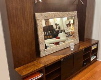 Contemporary wall unit media console with overhead lighting and built-in shelving storage.