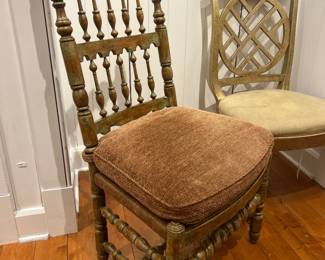 Vintage spindle-back wooden chair with turned legs and textured seat cushion.