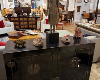 Standing Southeast Asian Buddha - carved wooden figure in the Thai/Burmese style sitting on a Black Lacquer Console. Also seen are African Tribal Masks.