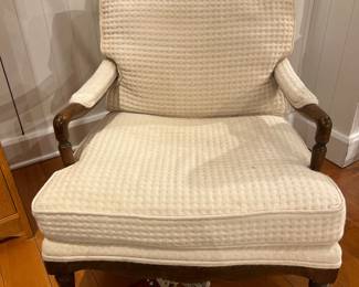 Vintage Upholstered Lounge Chair with Carved Wood Arms and Textured Cream Fabric.