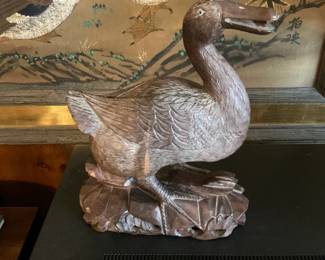 Hand-carved Chinese wooden duck figurine on textured wood base