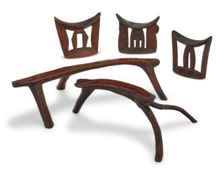 438 Five East African carved wood headrests 20th century Comprising three with incised details and two natural wood 5 pieces Largest: 6.125" H x 22.5" W x 13.125" D Estimate: $300 - $500