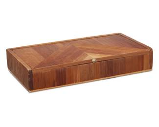 53 In the manner of Jean-Michel Frank (1895-1941) A straw marquetry box, second quarter 20th century The wood casket with hinged lid opening to reveal a cork-lined interior, with leather-clad underside 1.5" H x 8.25" W x 4.5" D Estimate: $400 - $600