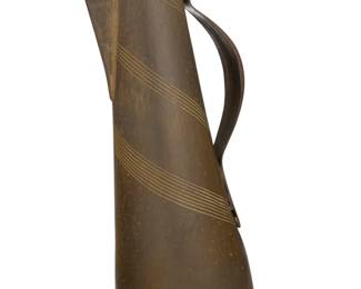 56 Hayno Focken (1905-1968) A hammered brass pitcher, circa 1930s Impressed to underside: Made in Germany / [cipher] / 1028 Incised with swirling lines and circles 19" H x 9.5" W x 7" D Estimate: $200 - $400