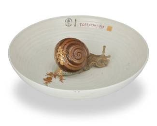 385 Hella Jongerius (b. 1963) A Nymphenburg porcelain 'Animal Bowl with Snail,' early 21st century Designed 2004 With impressed and printed factory marks; incised: 1762aJ27; further stamped: hella jongerius; painted: 2607/134/137 From the 'Animal Bowl' series, the snail depicted leaving behind a trail of gilt filigree, housed in original factory box Bowl: 2.25" H x 8" Dia.; Box: 3.125" H x 10.75" W x 10.75" D Estimate: $600 - $800