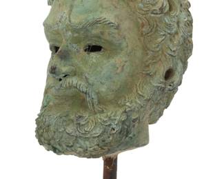 426 A Greek style bronze head 20th century With verdigris patination, raised on a metal rod issued from a concrete base Head: 9.25" H x 7" W x 8.375" D; Overall: 17" H x 8.5" W Estimate: $400 - $600