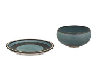 267 Harrison McIntosh (1914-2016) Two glazed stoneware vessels, mid-20th century Each impressed with potter's chop mark: HM; applied paper label to the underside: Handthrown Stoneware / Harrison McIntosh / Claremont / California Each with cerulean blue glaze, comprising a footed bowl and a plate with sgraffito lines to well interior 2 pieces Bowl: 2.875" H x 5.5" Dia.; Plate: 1" H x 8" Dia. Estimate: $600 - $800