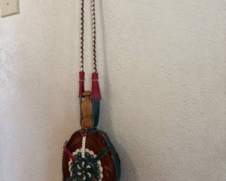 vintage handmade jug canteen folk art piece crafted with fur, leather, and decorative red and green material