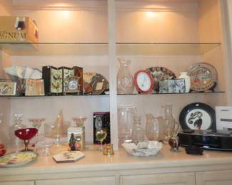 Shelves of decanters, barware,asian fans, Swedish red glass bowl, Bose Radio/CD, Erte plate, miniature screens and fans.