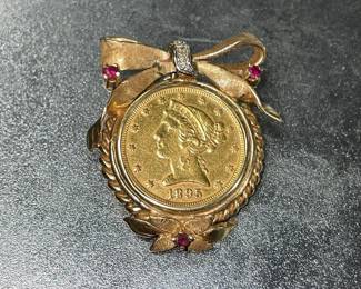 Five dollar gold piece with a 14 carat diamond and ruby bezel 