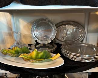Pewter plates or chargers, carved wood banana leaf dishes, 