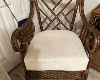 One of two Bamboo Rattan club chairs with curved arms and upholstered seats