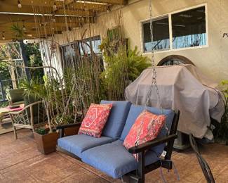 Chair swing includes blue cushions and chains