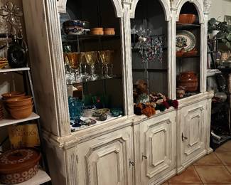 China cabinet display hutch with three arch display sections measures 78 inches across and 18 inches deep and is about 6.5 feet tall I believe it is lighted, but I haven’t found the cord to try it yet