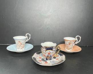 Porcelain Demitasse Cups and Saucers with Cherub and Floral Motif
