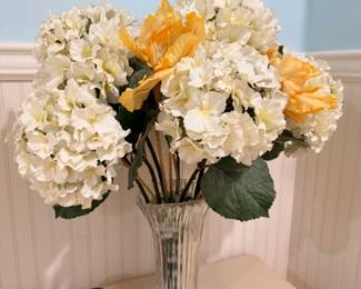 Silk flower arrangement in glass vase, yellow and white