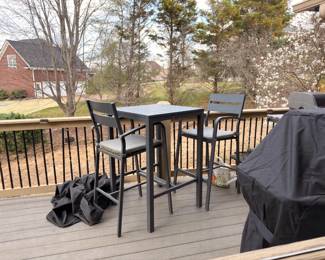 Outdoor bar-height patio table and chairs set on deck