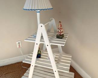 White ladder shelf with blue pleated shade table lamp