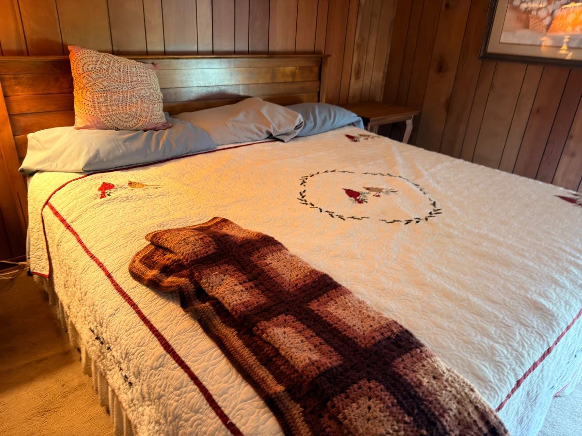 Antique wooden bed with handmade quilt bedspread