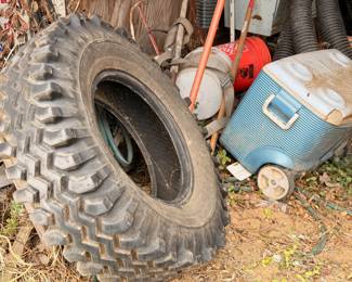 Large tractor tires, cooler, gas cans, and outdoor items