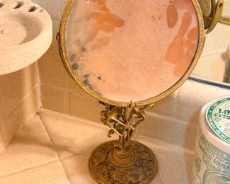 Antique brass vanity mirror on figurine pedestal base