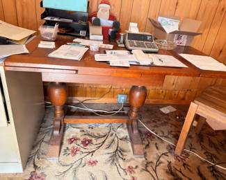 Turned-leg wooden desk with computer, office items, and area rug