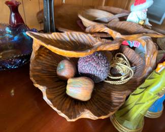 Carved wooden decorative tray with collectible figurines and pinecones