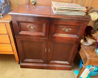 Dark wood buffet cabinet with brass hardware, vinyl records