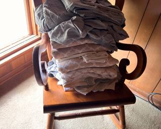 Antique wooden rocking chair with scrolled arms and linens