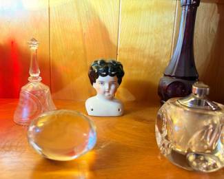 Antique porcelain doll head, crystal perfume bottles, glass decanter