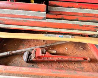 Pipe wrench and hand tools in red toolbox