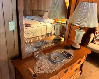Oak dresser with table lamps, doilies, and decorative items